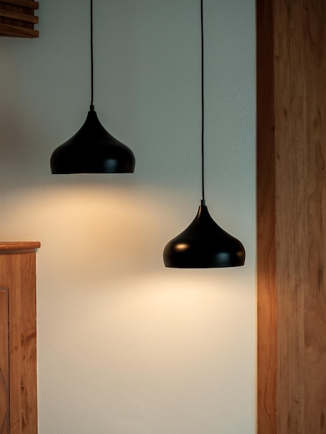 Iluminación de techo doble en la habitación oscura Dos lámparas colgantes o lámparas de techo redondas decoradas como escalones en estilo vertical de pared blanca y madera