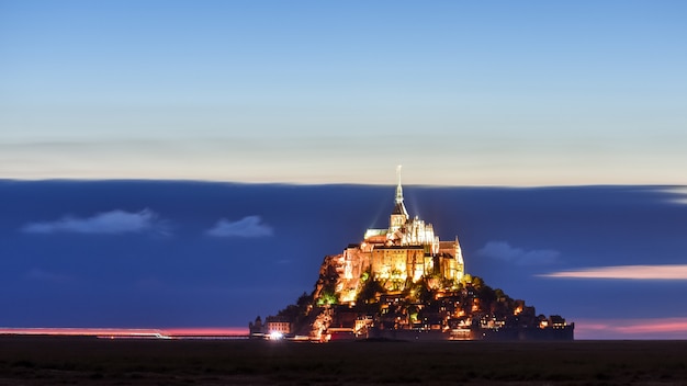 Iluminado Mont Saint Michel al atardecer en un cielo colorido