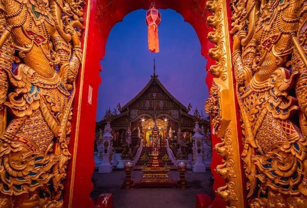 Iluminado en Wat Ming Muang contra el cielo al crepúsculo