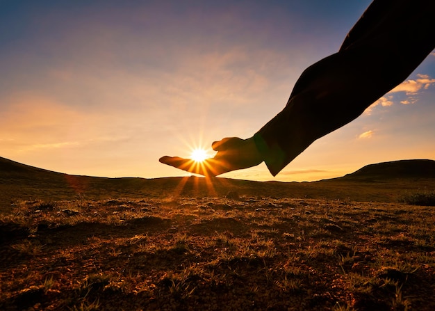 Foto ilusão óptica de mão segurando o sol