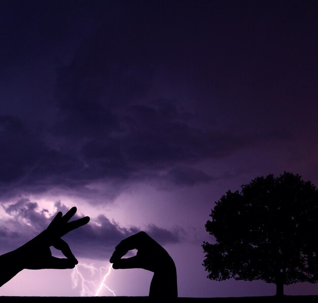 Foto ilusión óptica de una persona sosteniendo una tormenta que representa un espectáculo de marionetas por la noche