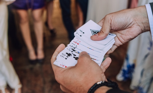 Ilusionista jugando a las cartas muestra trucos de fiesta