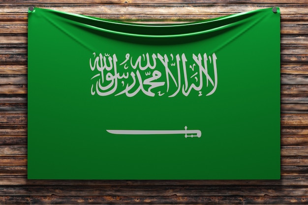 Foto ilustração da bandeira nacional de tecido da arábia saudita pregada em uma parede de madeira