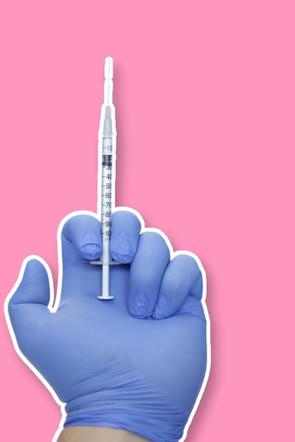 Foto ilustração de uma mão com seringa e luva azul