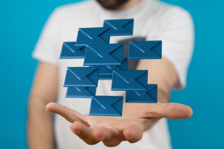 Foto ilustración en 3d de sobres azules que se ciernen sobre la palma de la mano de un hombre sobre un fondo azul