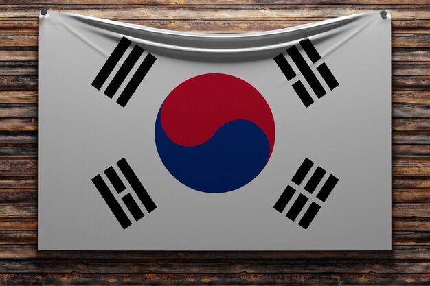 Foto ilustración de la bandera nacional de tela de corea del sur clavada en una pared de madera