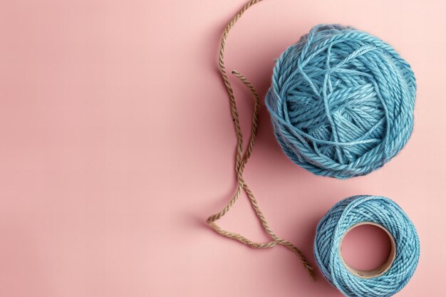 Ilustración de una bola de hilo azul sobre un fondo rosa claro vista desde arriba de una cuerda hecha de