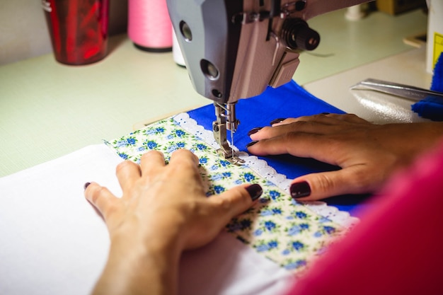 En esta ilustración fotográfica, una costurera trabajando en la máquina de coser en el taller de moda.