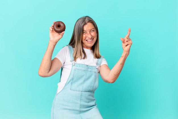 Im Alter hübsche Frau mit einem Donut