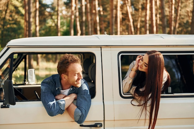 Im Auto sitzen Junges Paar ist tagsüber gemeinsam im Wald unterwegs