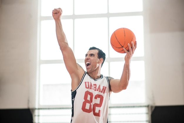 Im Fitnessstudio. Sportler, der in der Turnhalle vor dem Basketballspiel trainiert