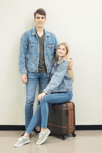 Im Flughafen wartet ein Paar auf das Einsteigen, in der Lounge warten Leute auf ihren Flug, ein junges fröhliches Paar posiert mit ihrem Gepäck