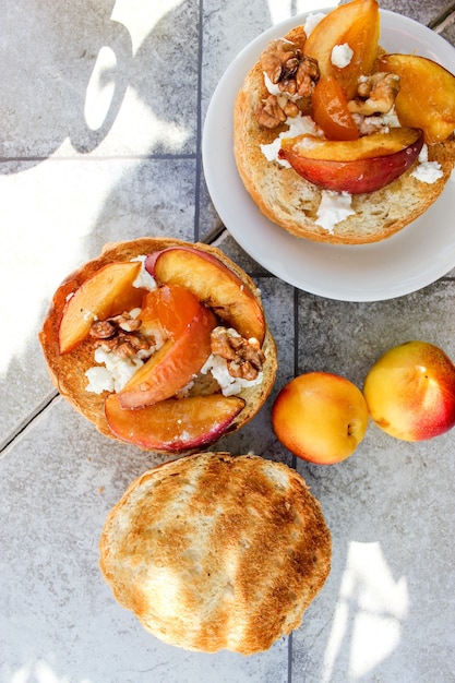 Im Freien Frühstück mit gegrillten Brötchen mit Ziegenfett, Obst, Nüssen, Orangensaft und Kaffee