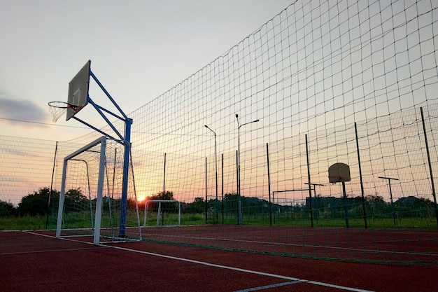 Im Freien Mini-Fußball- und Basketballplatz mit Balltor und Korb, umgeben von hohem Schutzzaun.