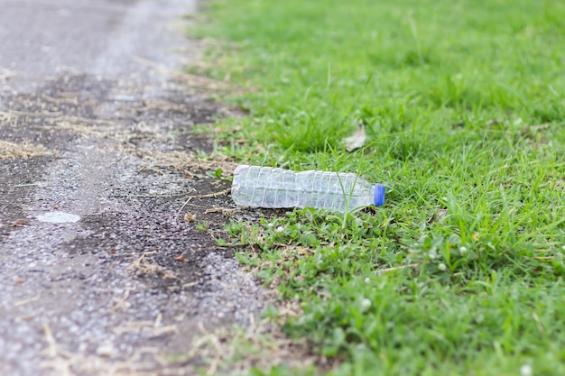 Foto im gartenpark wurden von jemandem plastikflaschen an den straßenrand gestellt. abfall und umweltverschmutzung. umweltkonzept speichern