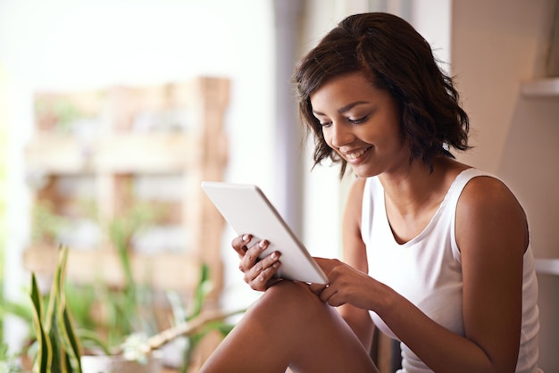 Im Internet gibt es immer etwas Neues zu sehen Aufnahme einer jungen Frau, die zu Hause ein digitales Tablet verwendet