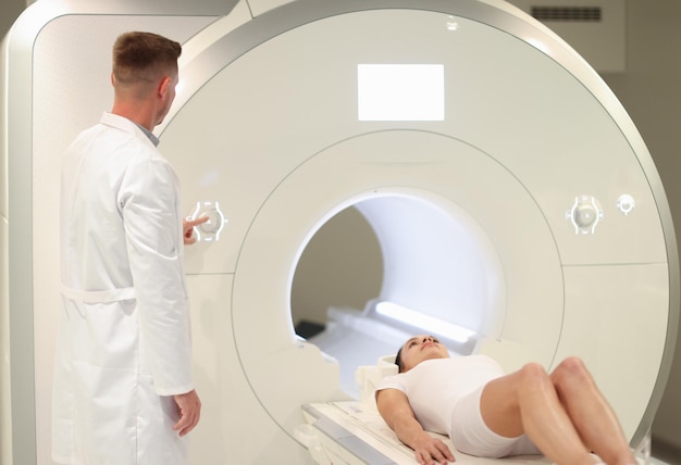 Im medizinischen Labor steuert der männliche Radiologe mri- oder ct-Scan mit High-Tech-Patienten