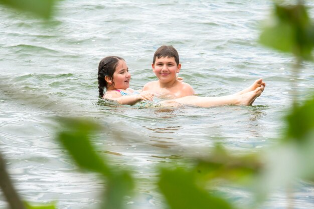 Im Sommer baden Bruder und Schwester im Fluss