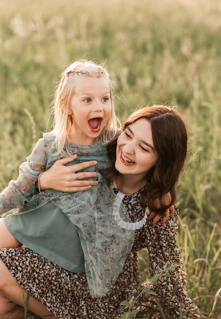 Foto im sommer spazieren ältere und jüngere schwestern gemeinsam in der natur. schwester umarmt und beruhigt