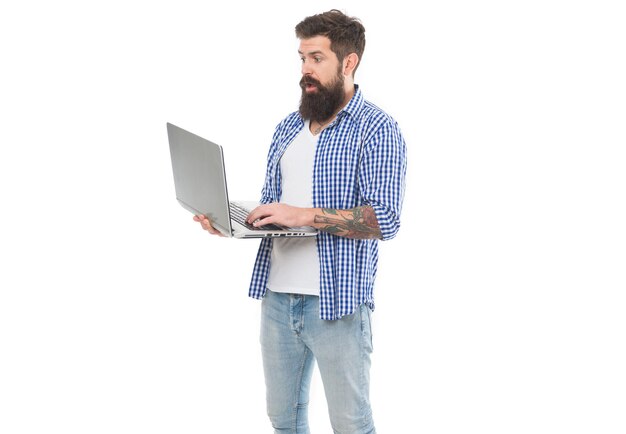 Im trendigen Hipster-Stil Hipster, der am Computer arbeitet Bärtiger Hipster, der mit modernem Laptop in den Händen hält Brutaler kaukasischer Hipster, der neue Computertechnologien verwendet