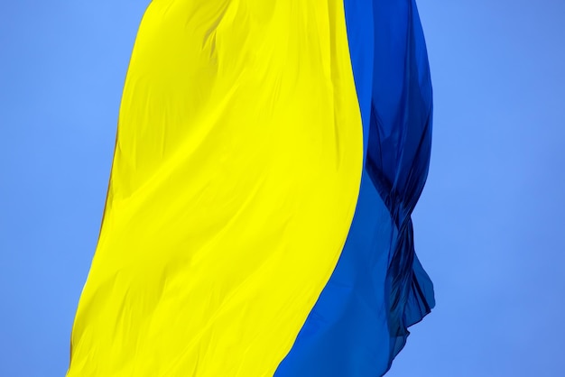 Im Wind weht die Nationalflagge der Ukraine gegen den blauen Himmel