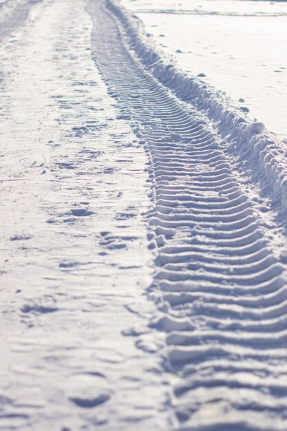 Im Winter frische Spuren vom Traktor im Schnee. Schneeräumung