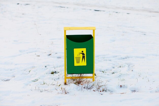 Im Winter steht im Park eine grüne Metallurne. Urne