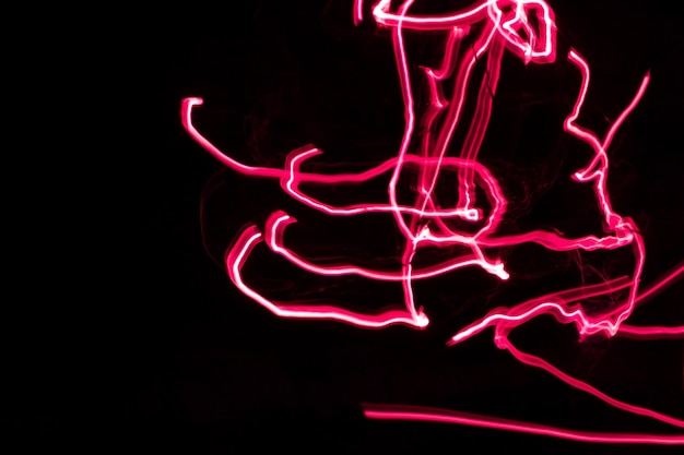 Imagem abstrata de quadro completo de trilhas de luz neon vermelha contra fundo preto copiar para texto