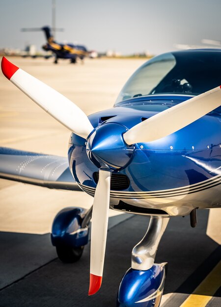 Imagem aproximada da hélice branca do nariz do avião esportivo azul