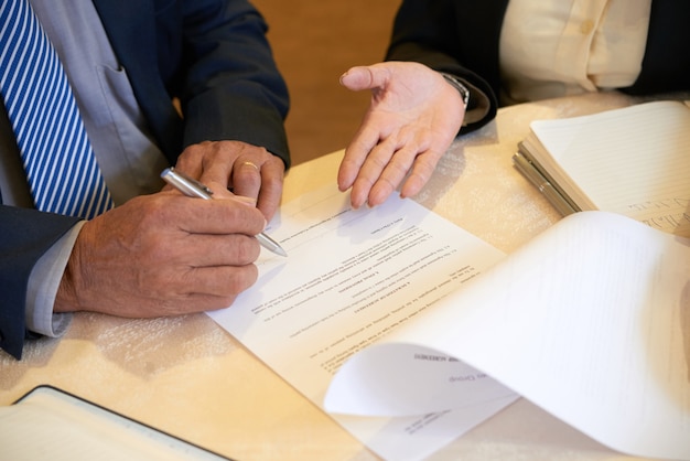 Foto imagem aproximada de parceiros de negócios assinando contrato após uma reunião bem-sucedida