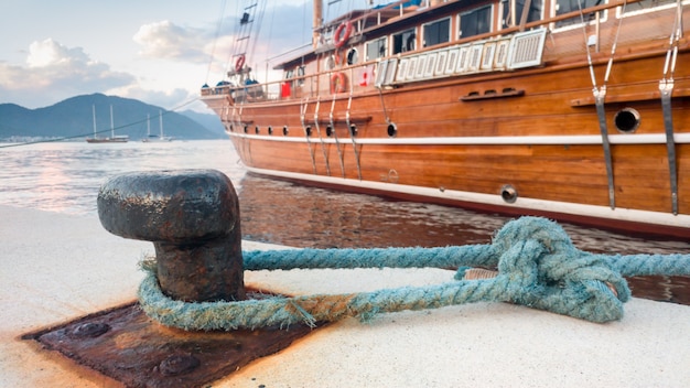 Imagem aproximada de um grande e histórico navio de madeira atracado no porto marítimo