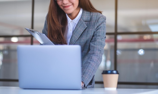 Imagem aproximada de uma bela jovem empresária asiática usando laptop enquanto trabalhava no escritório