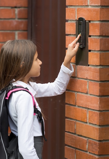 Imagem aproximada de uma colegial bonita tocando a campainha