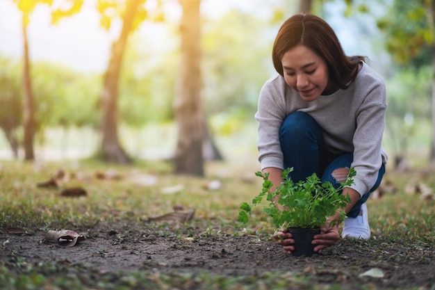 Imagem aproximada de uma jovem asiática cultivando plantas no jardim