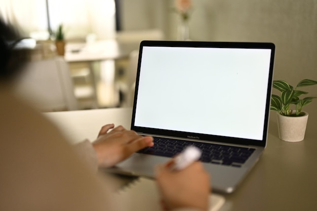 Imagem aproximada de uma mulher freelancer gerenciando seu trabalho no laptop em casa