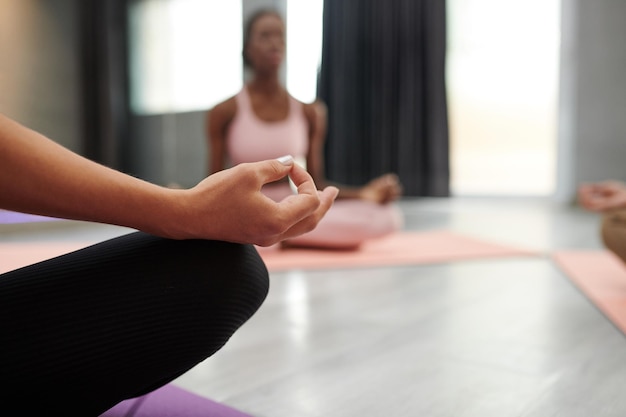 Imagem aproximada de uma mulher mantendo as mãos no mudra ao meditar