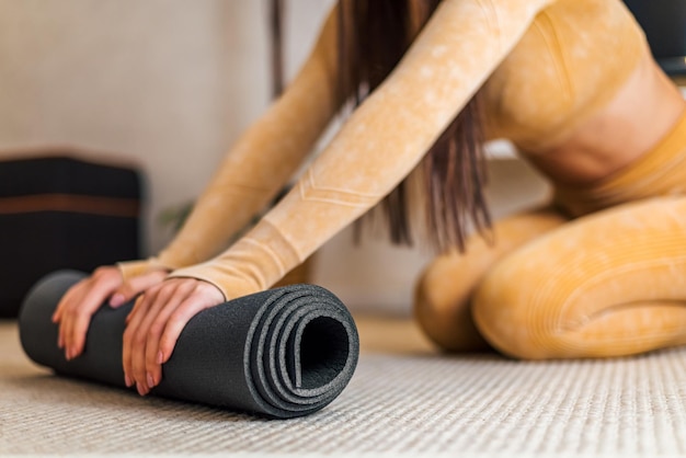 Imagem aproximada do tapete de ioga sendo dobrado após a rotina matinal