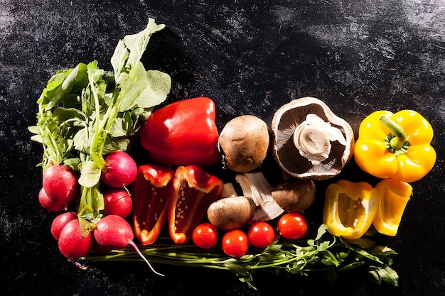 Imagem artística de diferentes tipos de vegetais orgânicos saudáveis em fundo escuro em foto de estúdio