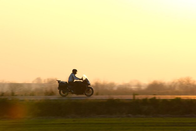 Imagem borrada de movimento de motocicleta dirigindo rápido na estrada à noite