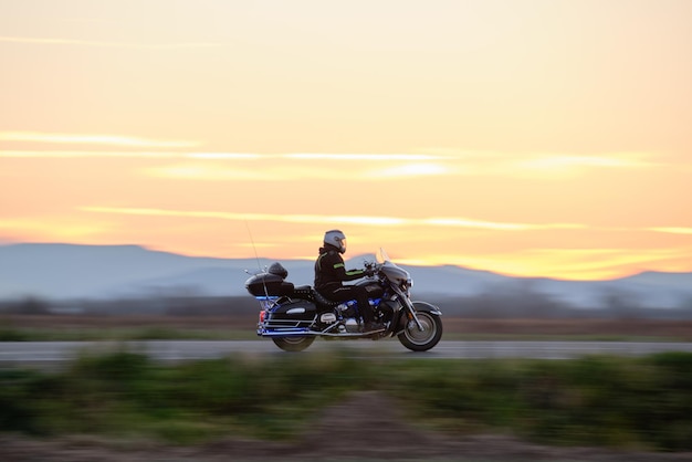 Imagem borrada de movimento de motocicleta dirigindo rápido na estrada à noite