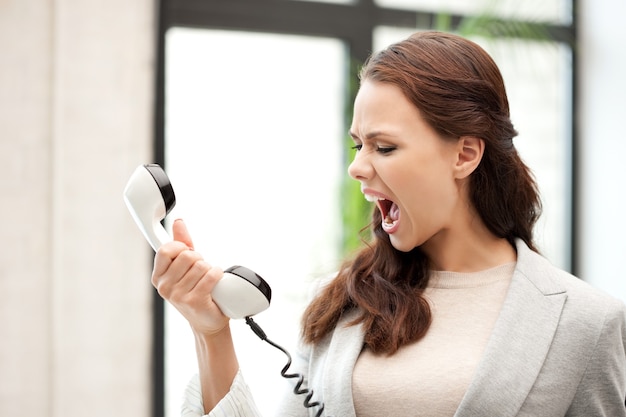 imagem brilhante de mulher de negócios zangada com o telefone