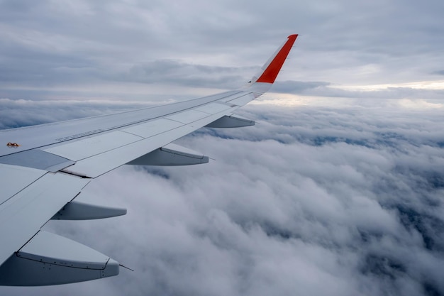 Imagem clássica através da janela da aeronave para a vista do voo da asa sobre as nuvens