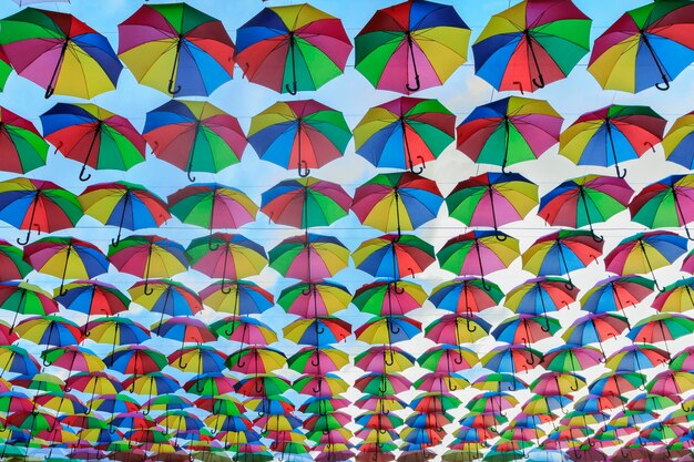 Imagem completa de guarda-chuvas multicoloridas penduradas ao ar livre