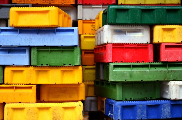 Foto imagem completa de recipientes de plástico coloridos empilhados no mercado de peixes