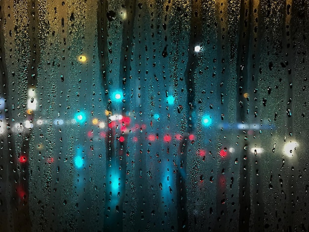Imagem completa de uma janela de vidro molhada à noite