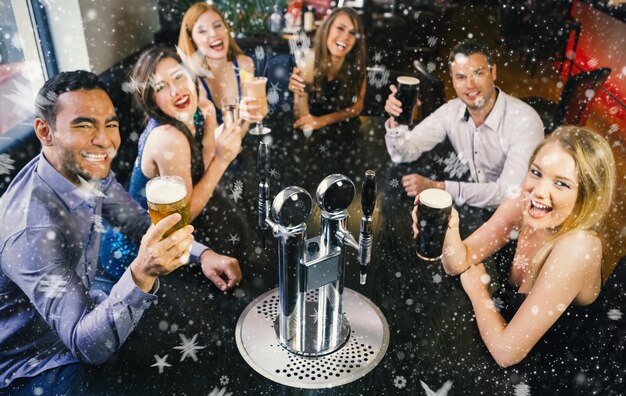 Foto imagem composta de amigos rindo levantando seus copos contra a neve