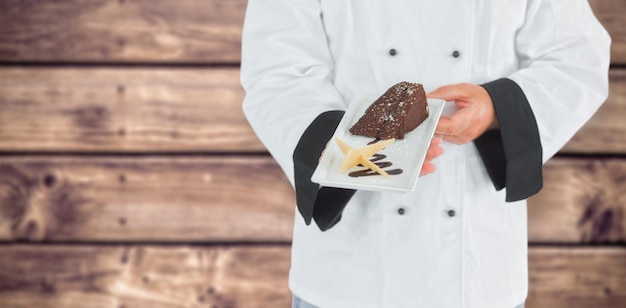 Imagem composta de close-up em um chef segurando um bolo de chocolate
