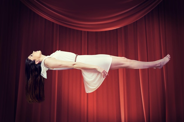Imagem composta de garota de vestido branco flutuando no ar