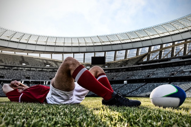 Imagem composta de jogador de rugby deitado no campo
