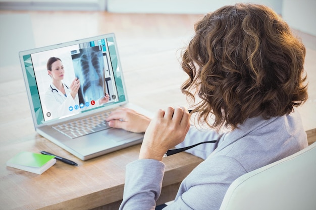 Foto imagem composta de mulher de negócios usando laptop na mesa de escritório criativo